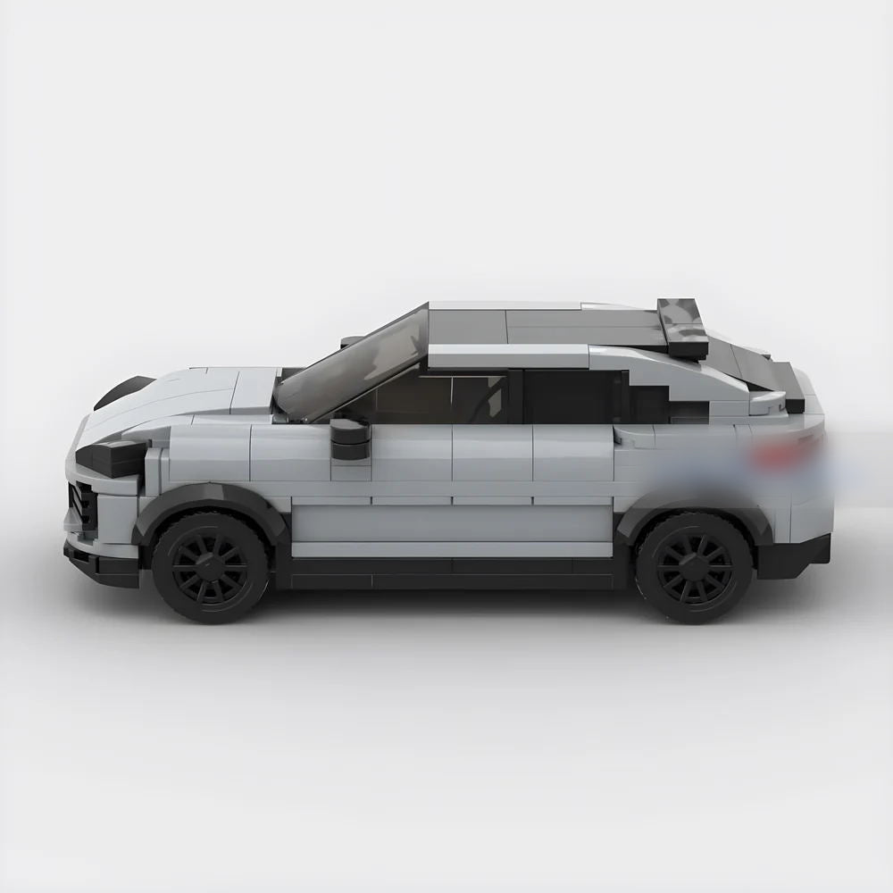 Side view of gray LEGO model car with black wheels and a rear spoiler on white background