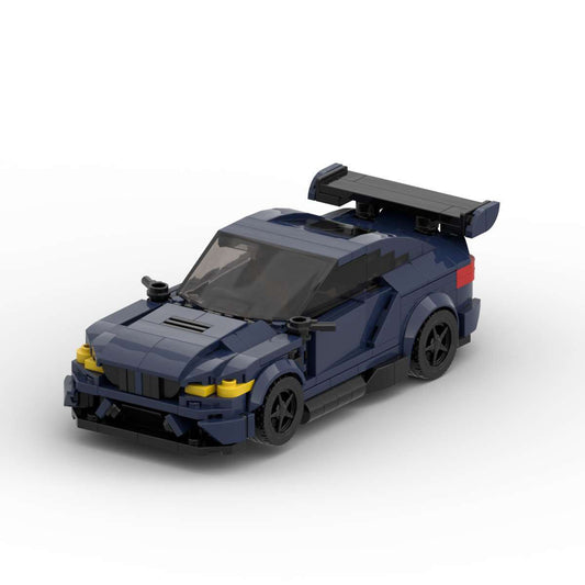 Dark blue LEGO model of BMW M3 GTS with black spoiler and black wheels on white background