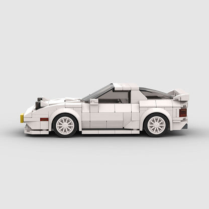 RevVBlox Mazda RX-7 FC3S model car in detailed white with orange accents, showcasing the classic sports car design.