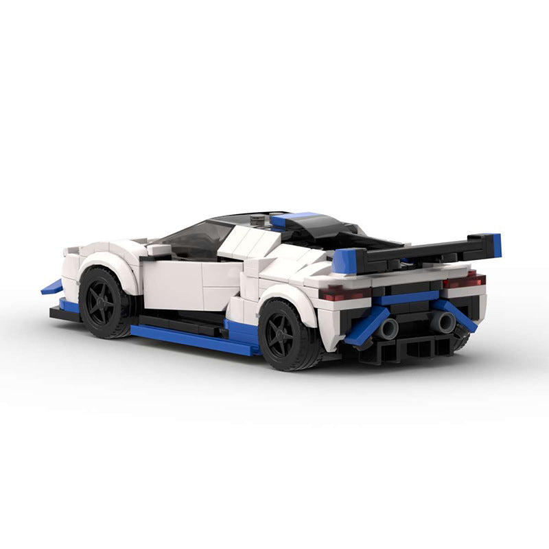 White and blue Lego sports car model with rear spoiler and black wheels on white background