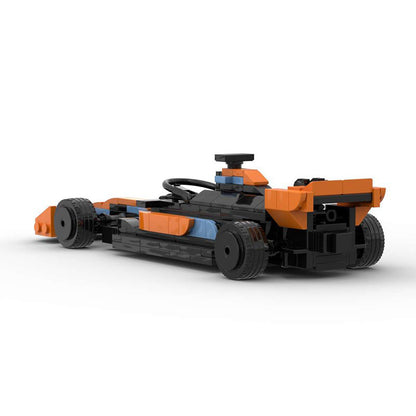 Black and orange Lego race car toy model with large rear spoiler and detailed cockpit