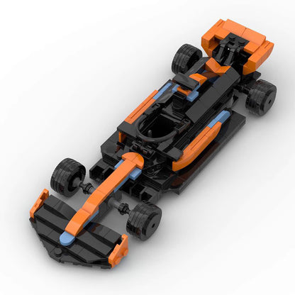 Black and orange LEGO Formula 1 race car model with wide tires and aerodynamic design