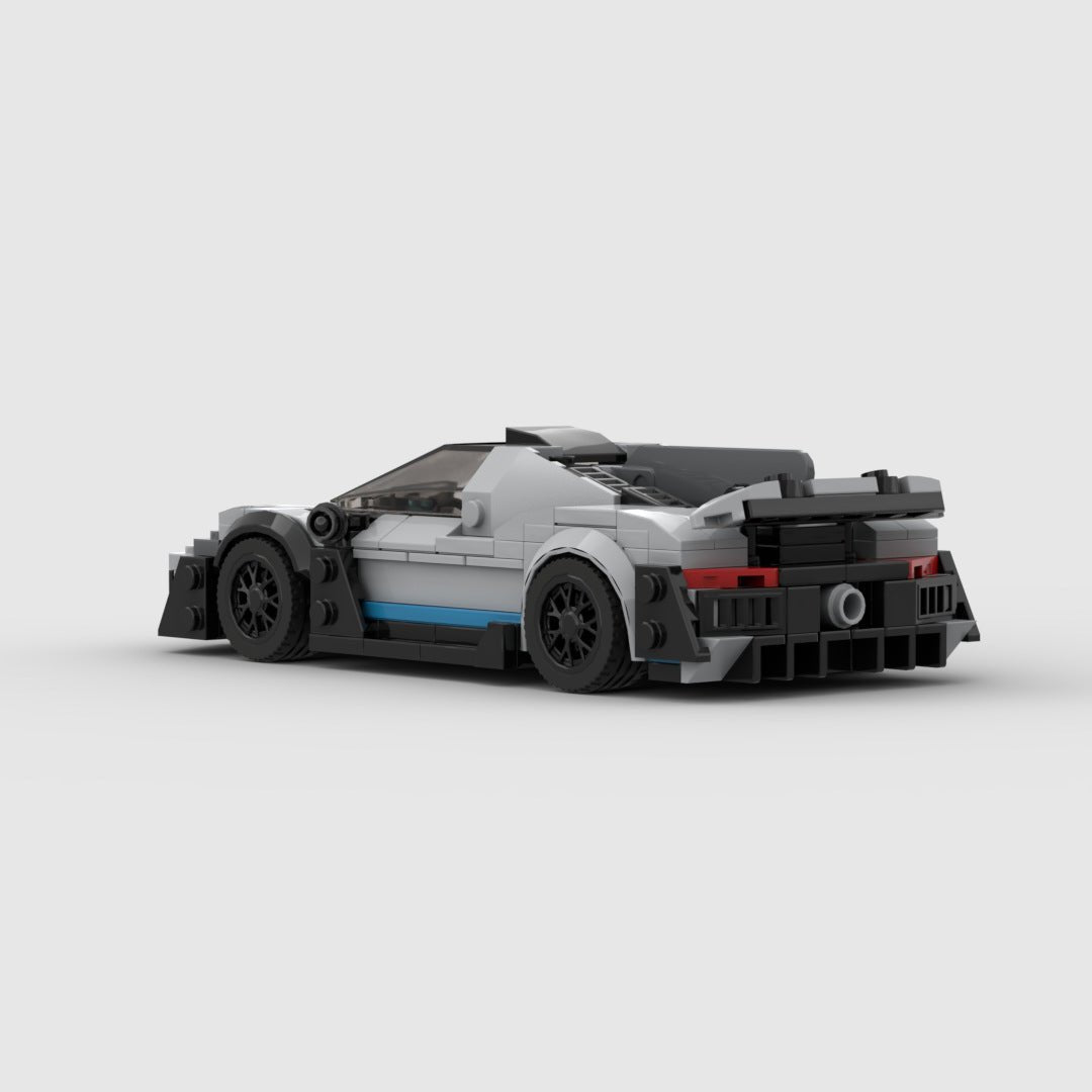 Lego model of a gray race car with black wheels and blue stripe on plain white background