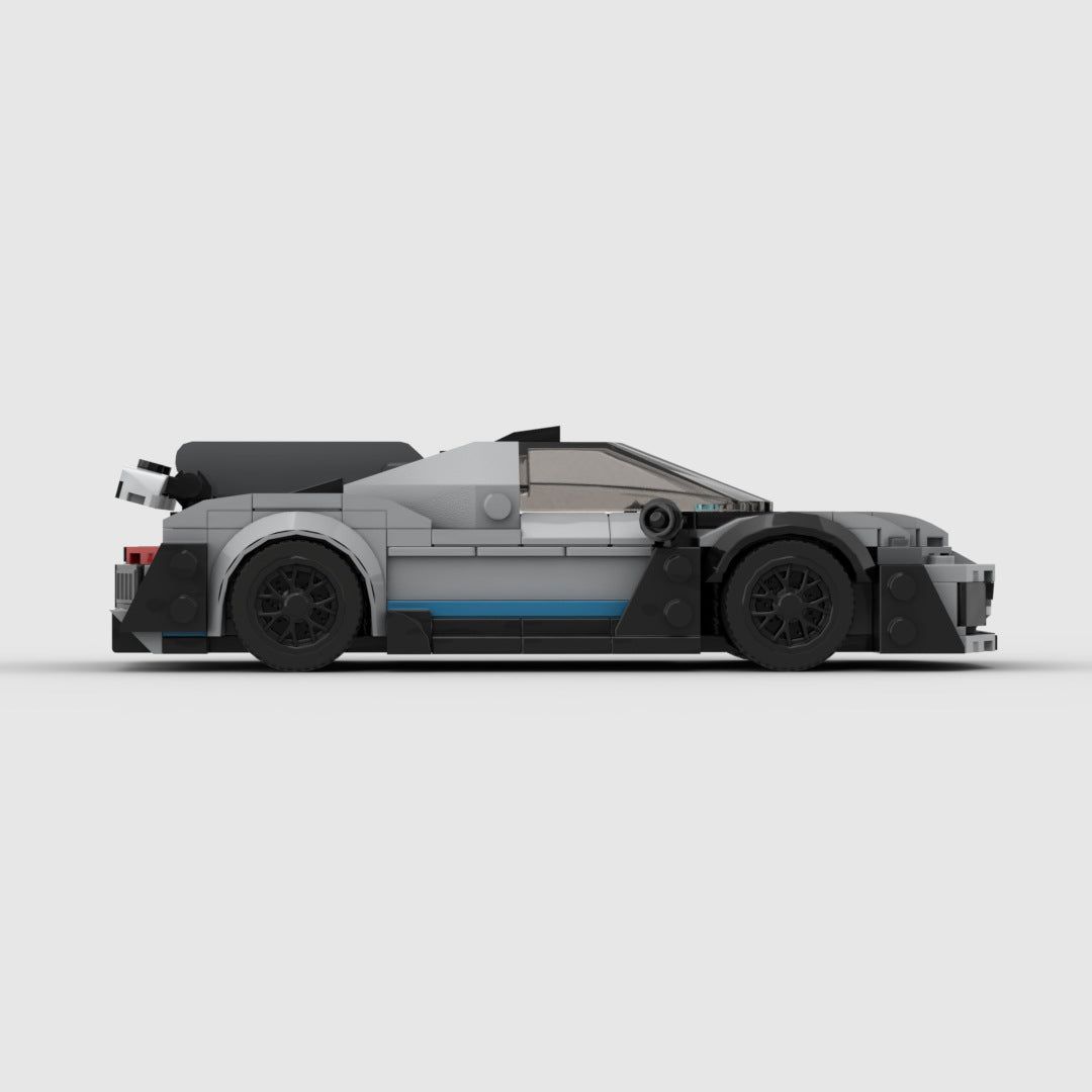 Side view of LEGO model sports car with grey body, black wheels, and blue accent strip