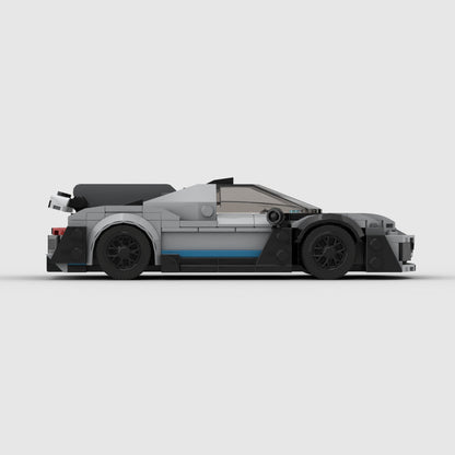 Side view of LEGO model sports car with grey body, black wheels, and blue accent strip