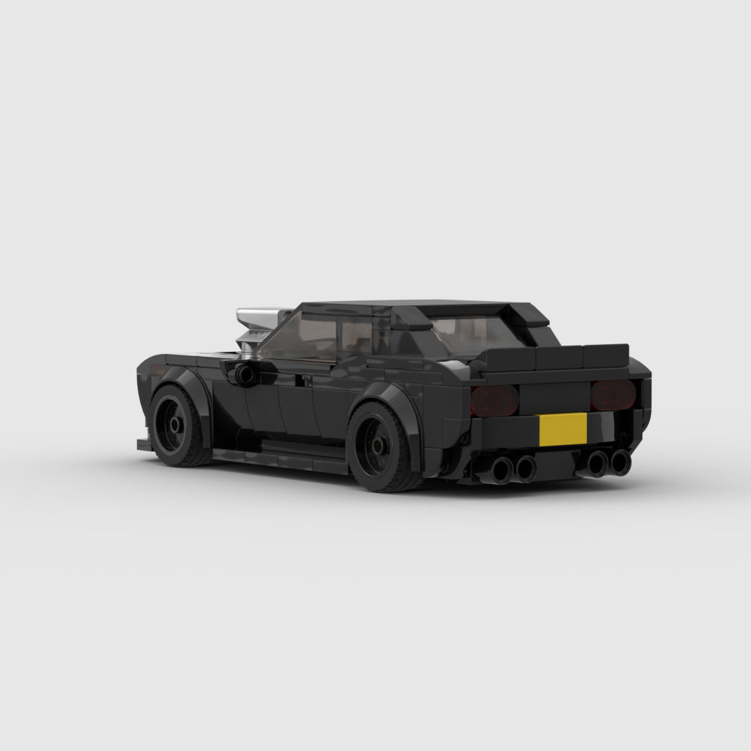 Black LEGO model of a sports car with rear spoiler and quad exhausts on white background