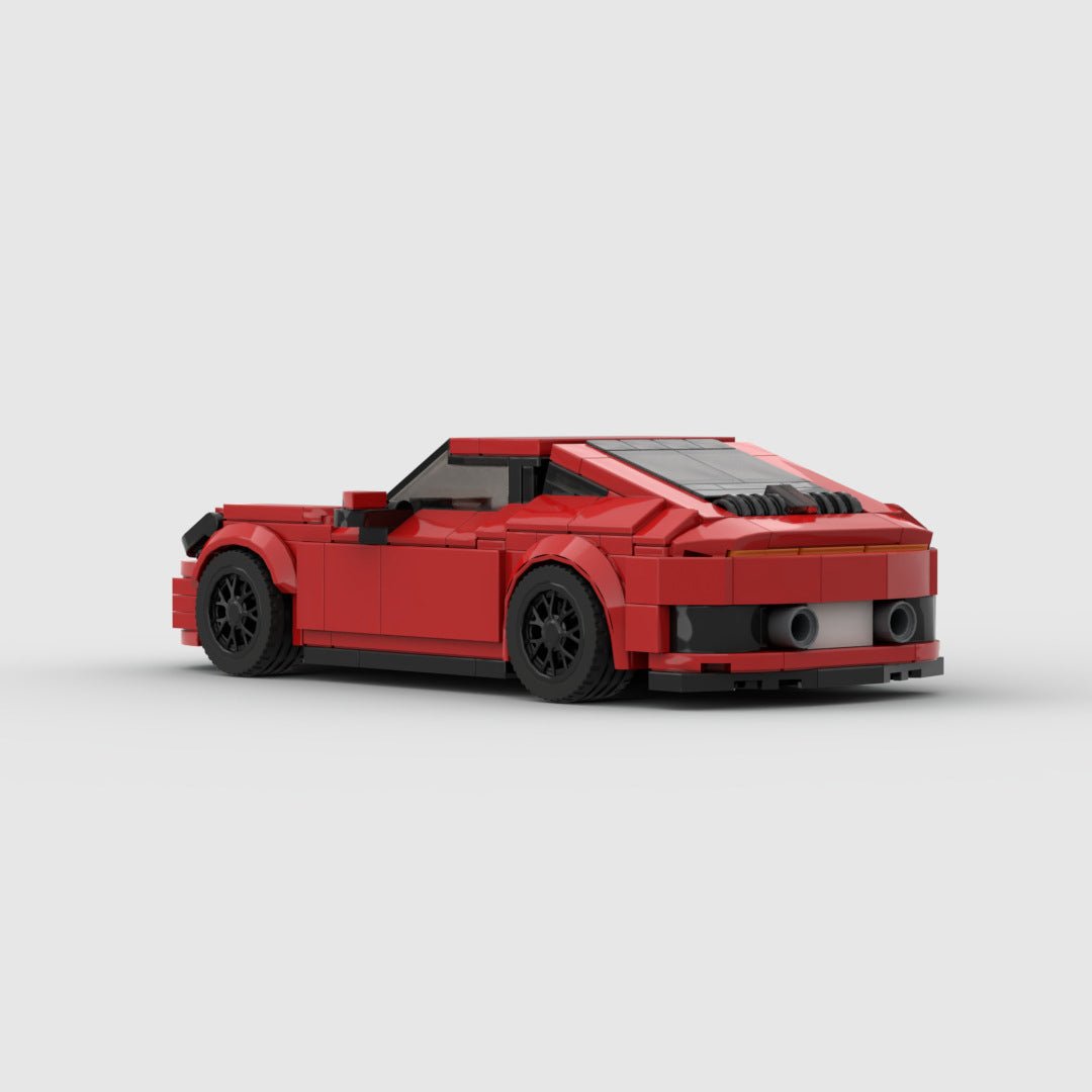 Red LEGO model of a Porsche 911 Carrera sports car with black wheels on a plain white background