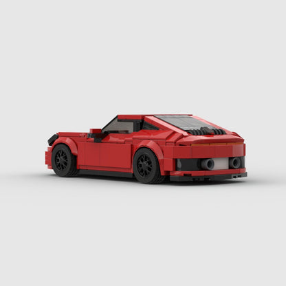 Red LEGO model of a Porsche 911 Carrera sports car with black wheels on a plain white background