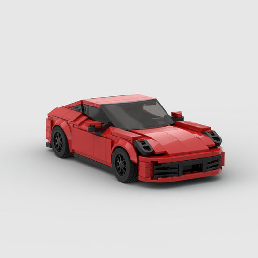Red LEGO model of Porsche 911 Carrera sports car with black wheels on gray background