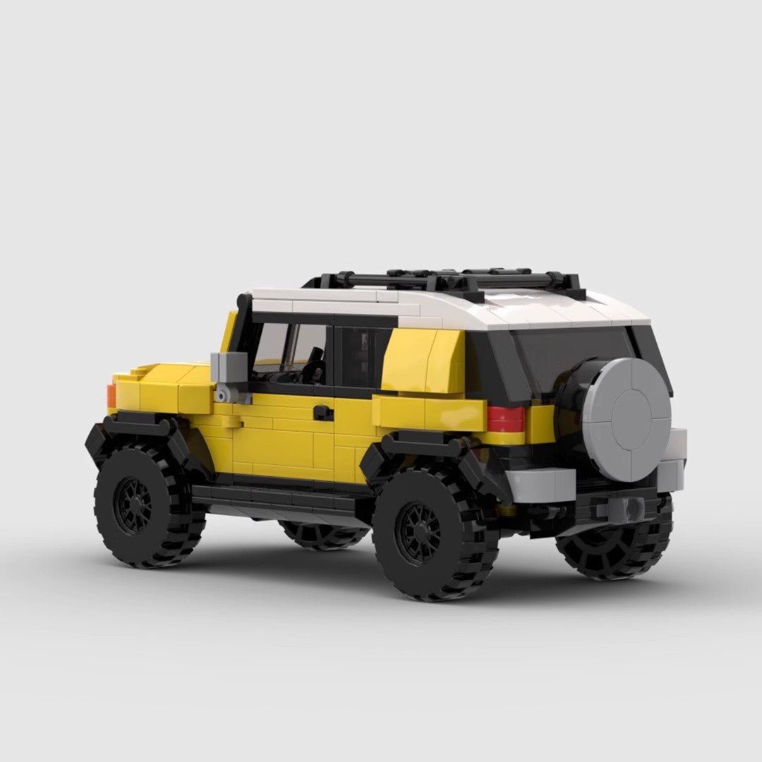 Yellow and white LEGO Toyota FJ Cruiser model with black tires on gray background