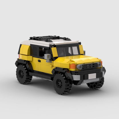 Yellow and white LEGO model of Toyota FJ Cruiser SUV with black roof rack and off-road tires